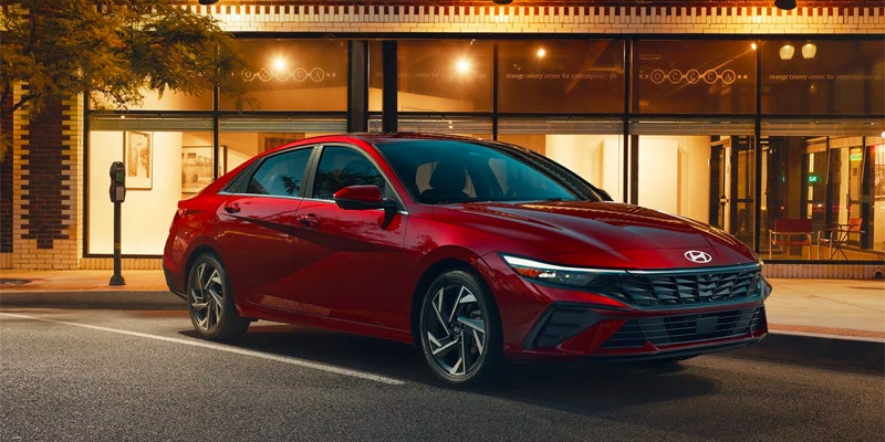 A red 2024 Hyundai ELANTRA N Insight parked, showcasing its sleek design and modern features.