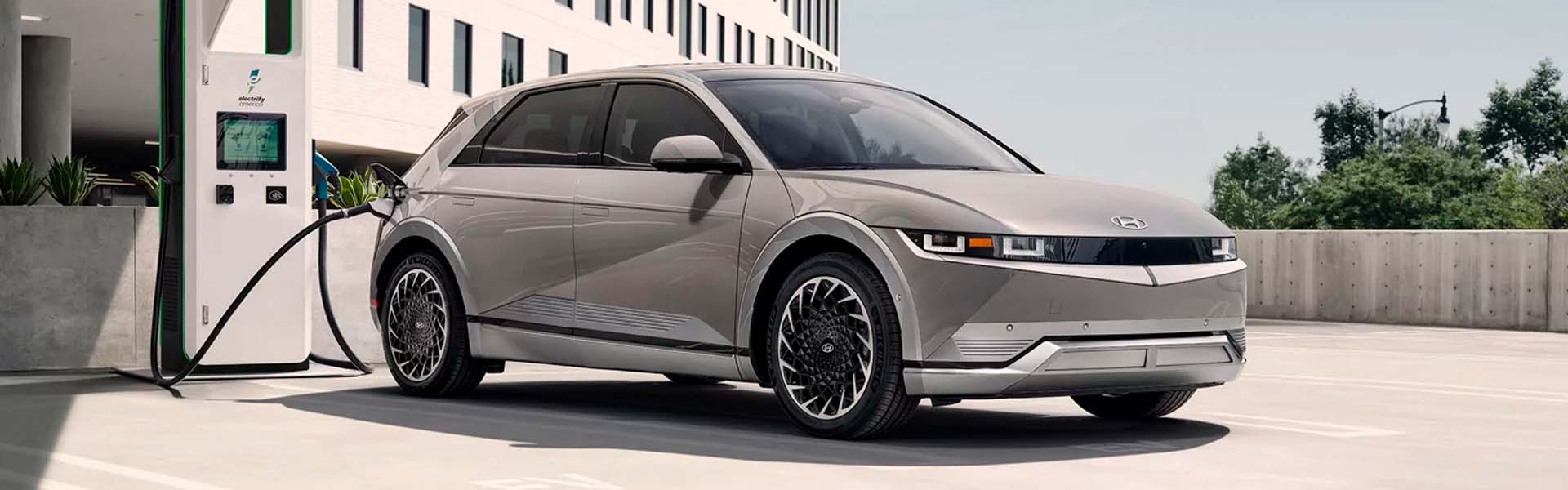 White Hyundai Ioniq 5 parked in a charging station waiting to be fully charged while the day goes by