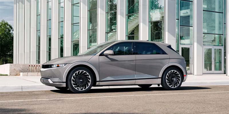 White Hyundai Ioniq parked on the street next to a large building during the day