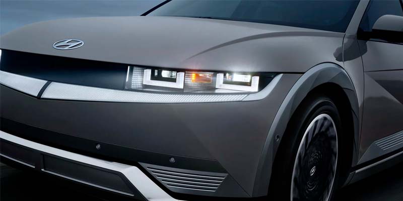 Front view of a gray SUV parked on a road, showcasing its sleek design and modern features.